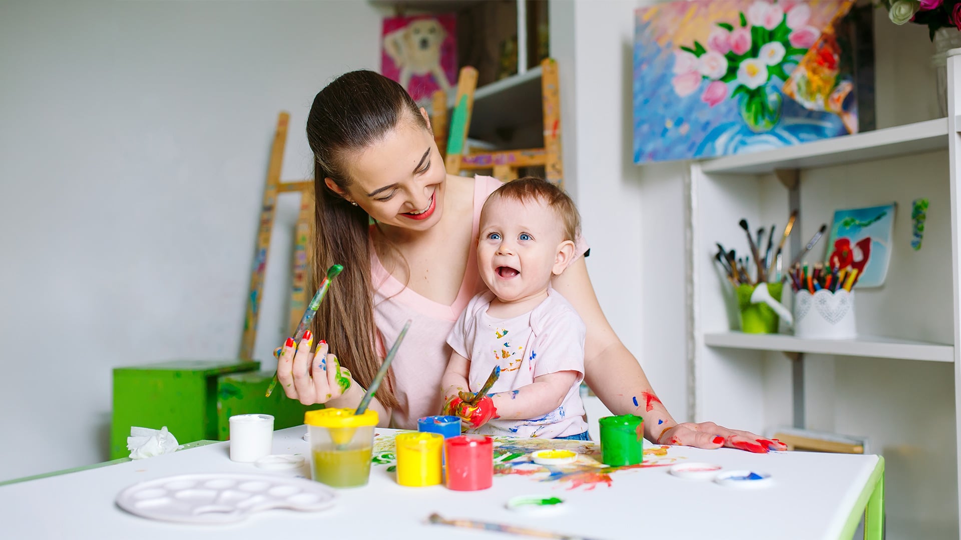 Mother and baby painting together at an art table