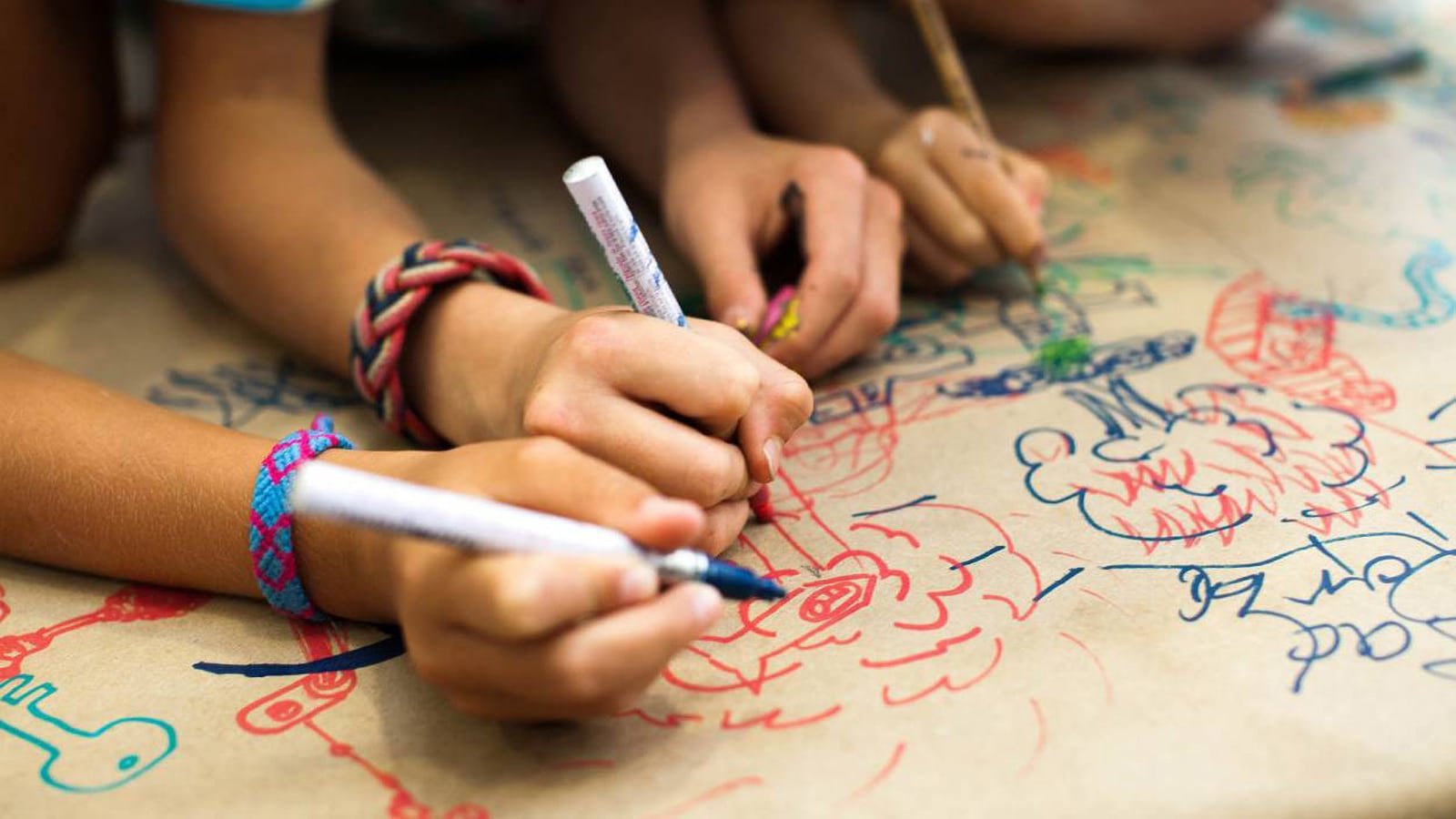 Children drawing colorful doodles on paper