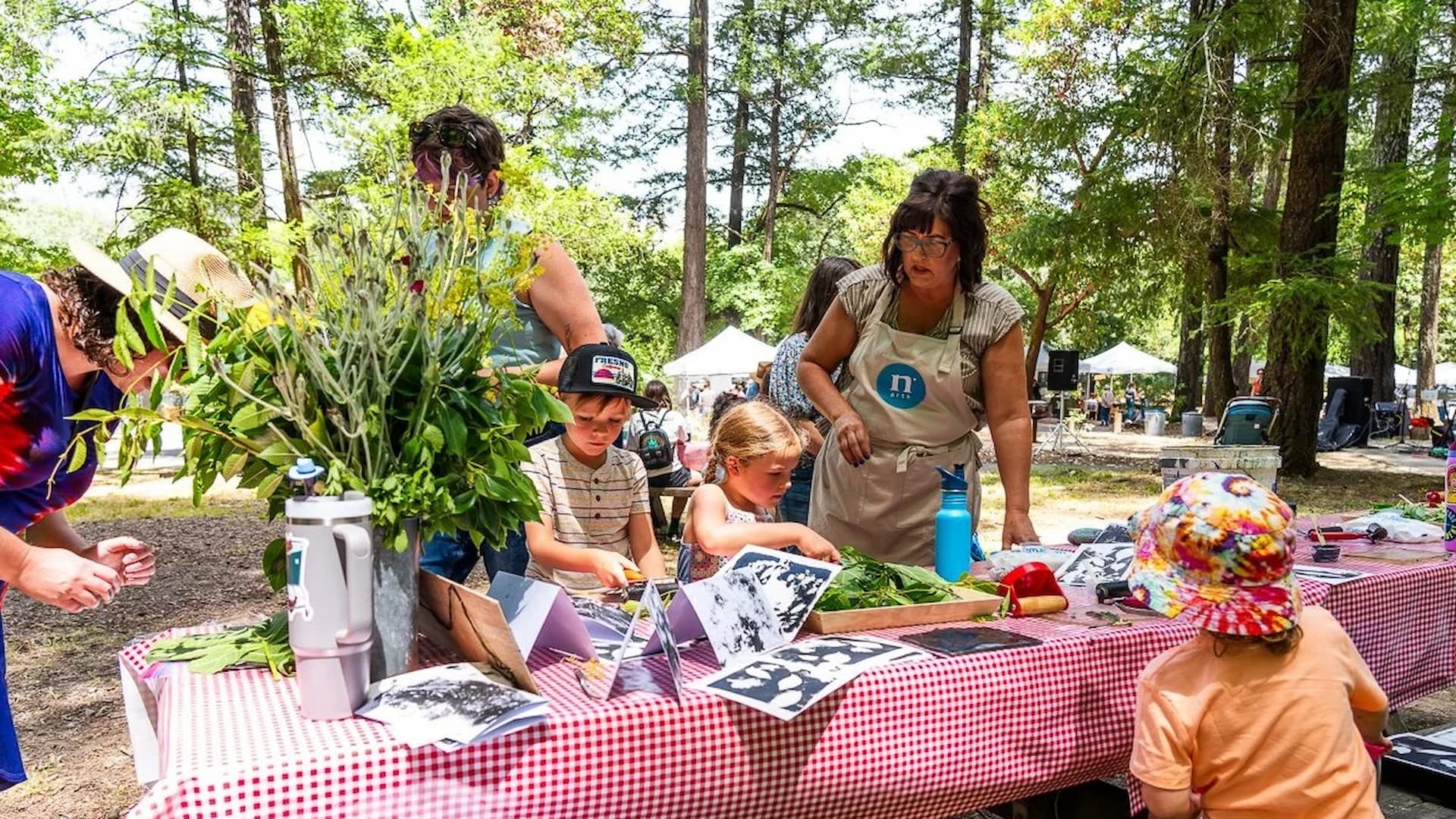 Children making leaf prints at outdoor workshop