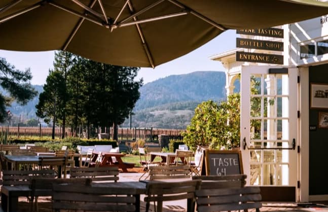 Outdoor winery patio with vineyard and hills