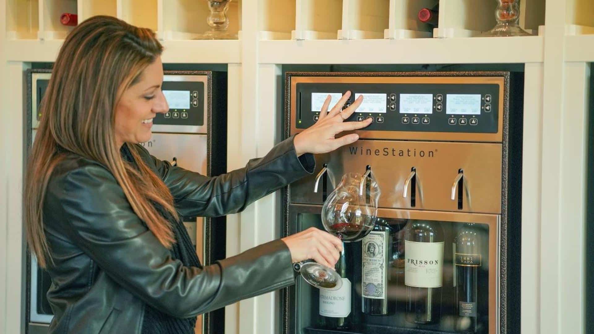 Woman using wine dispenser with glass