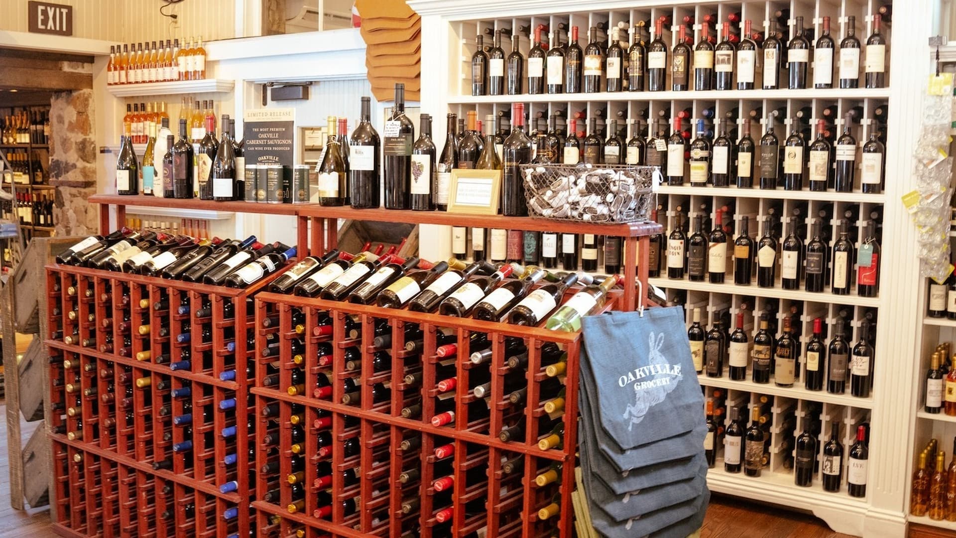 Wine bottles displayed on wooden racks in store.