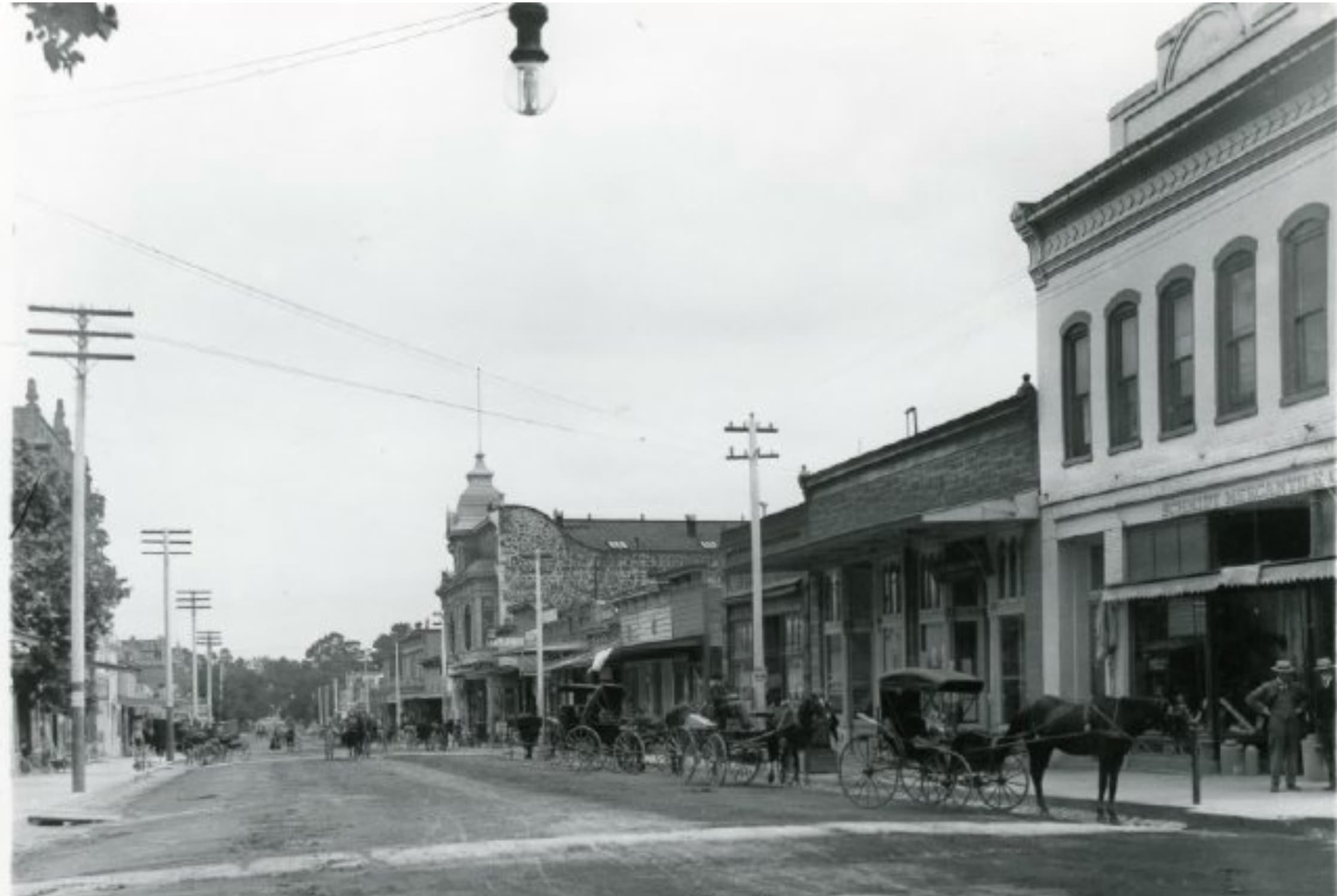 Historic street with horse-drawn carriages and old buildings