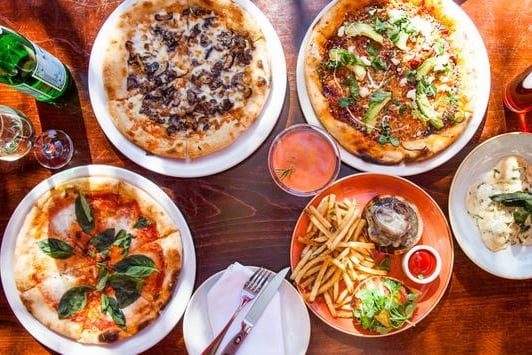 Top view of pizzas, fries, and drinks