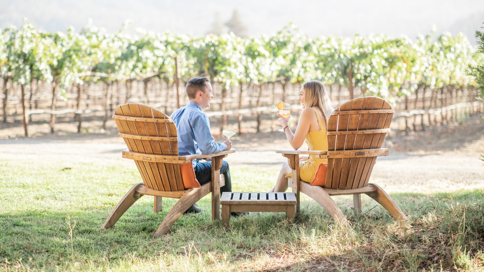 Couple enjoying wine in vineyard chairs