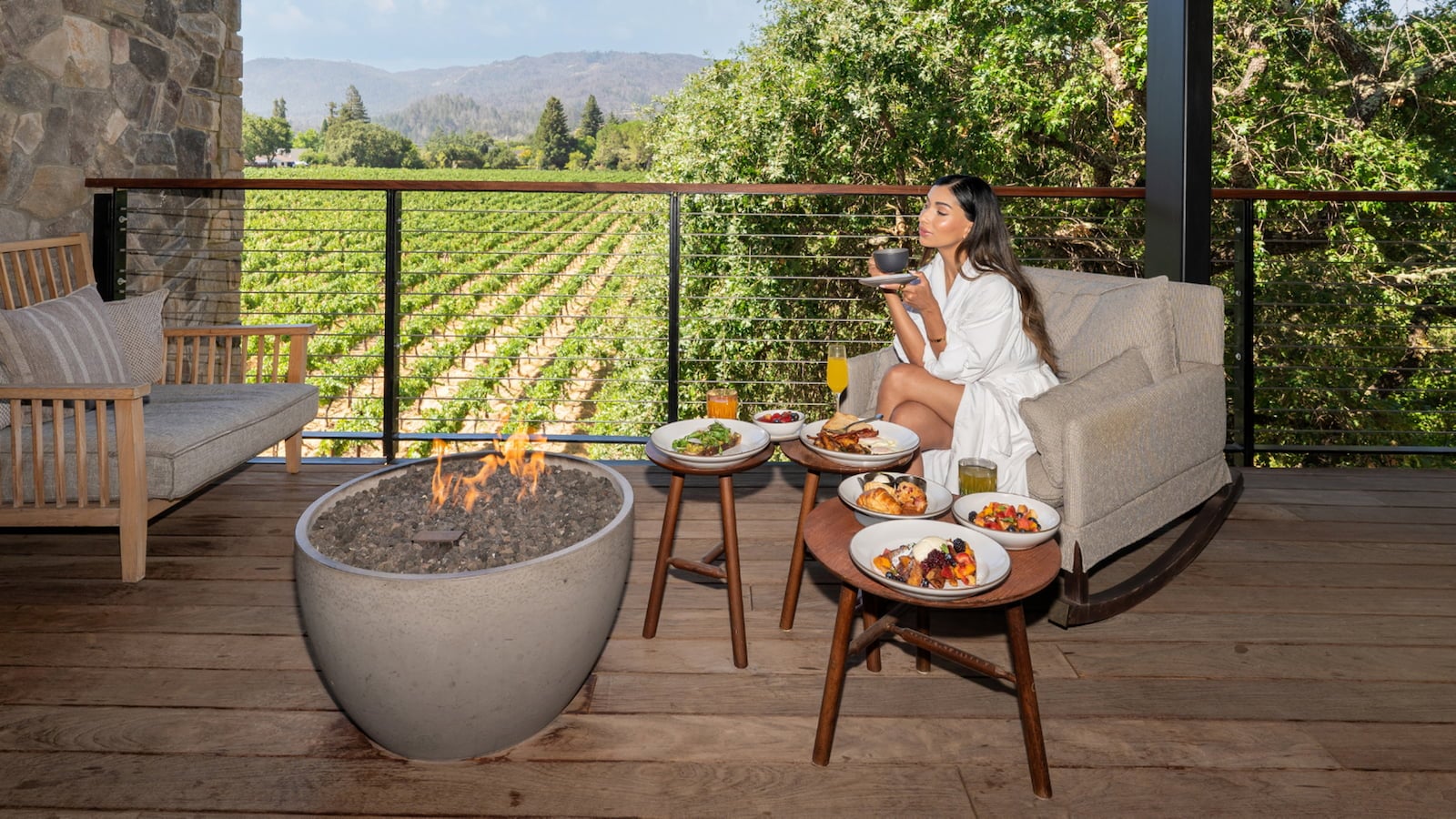 Woman enjoying breakfast overlooking vineyard from balcony