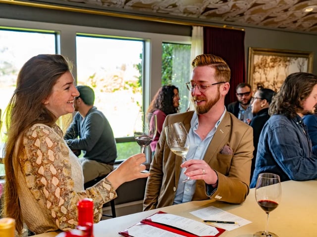 Guests tasting wine at an indoor social gathering