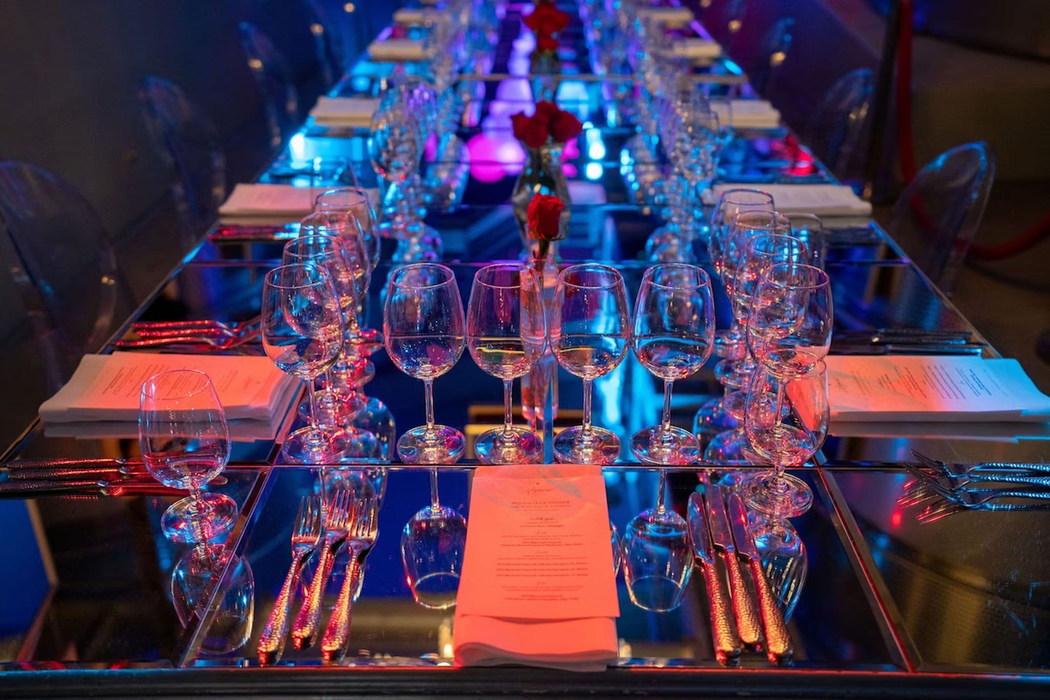Elegant table setting with wine glasses and menus.