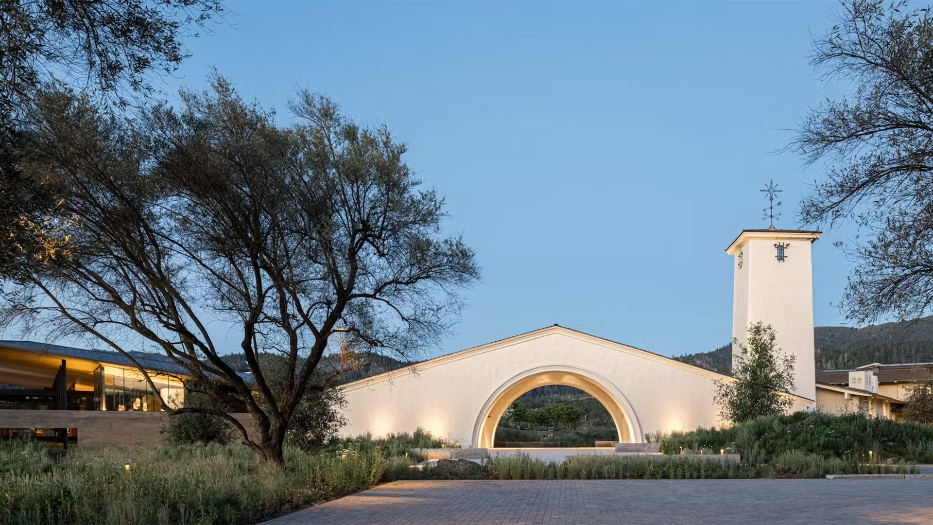 Illuminated church arch and bell tower at dusk