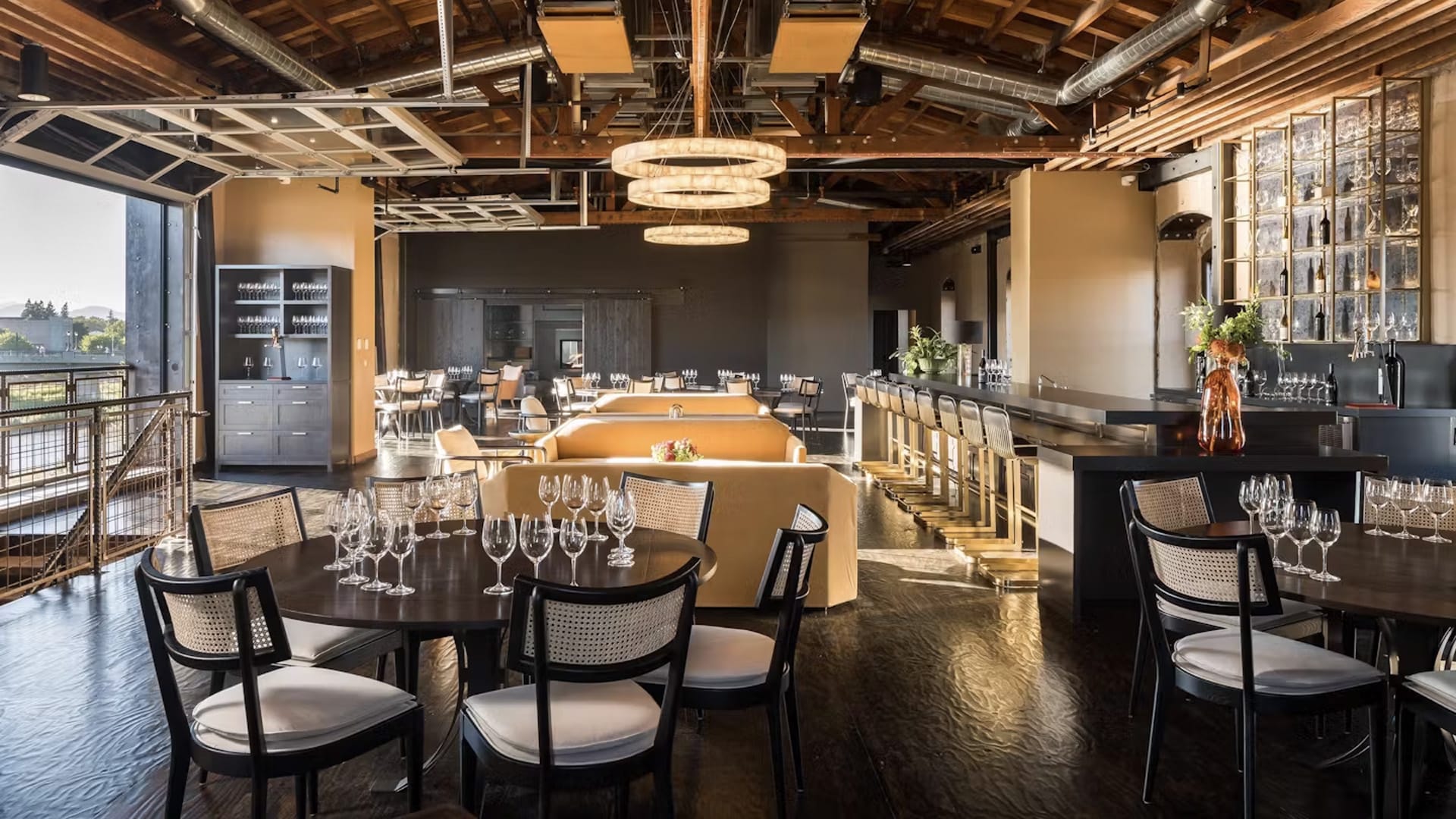 Modern restaurant interior with tables and bar seating.