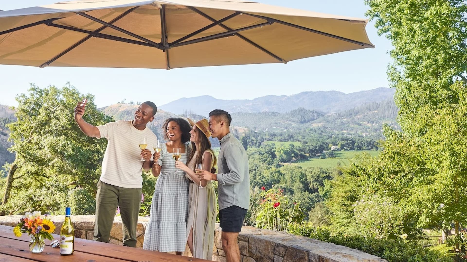 Friends enjoying wine outdoors in scenic vineyard