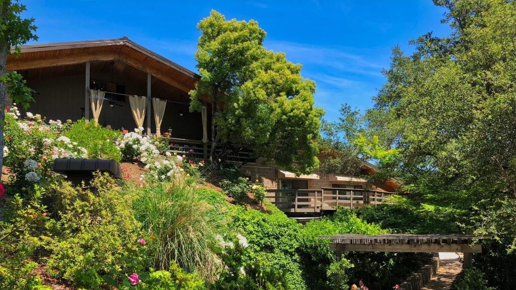 House surrounded by lush garden and blue sky