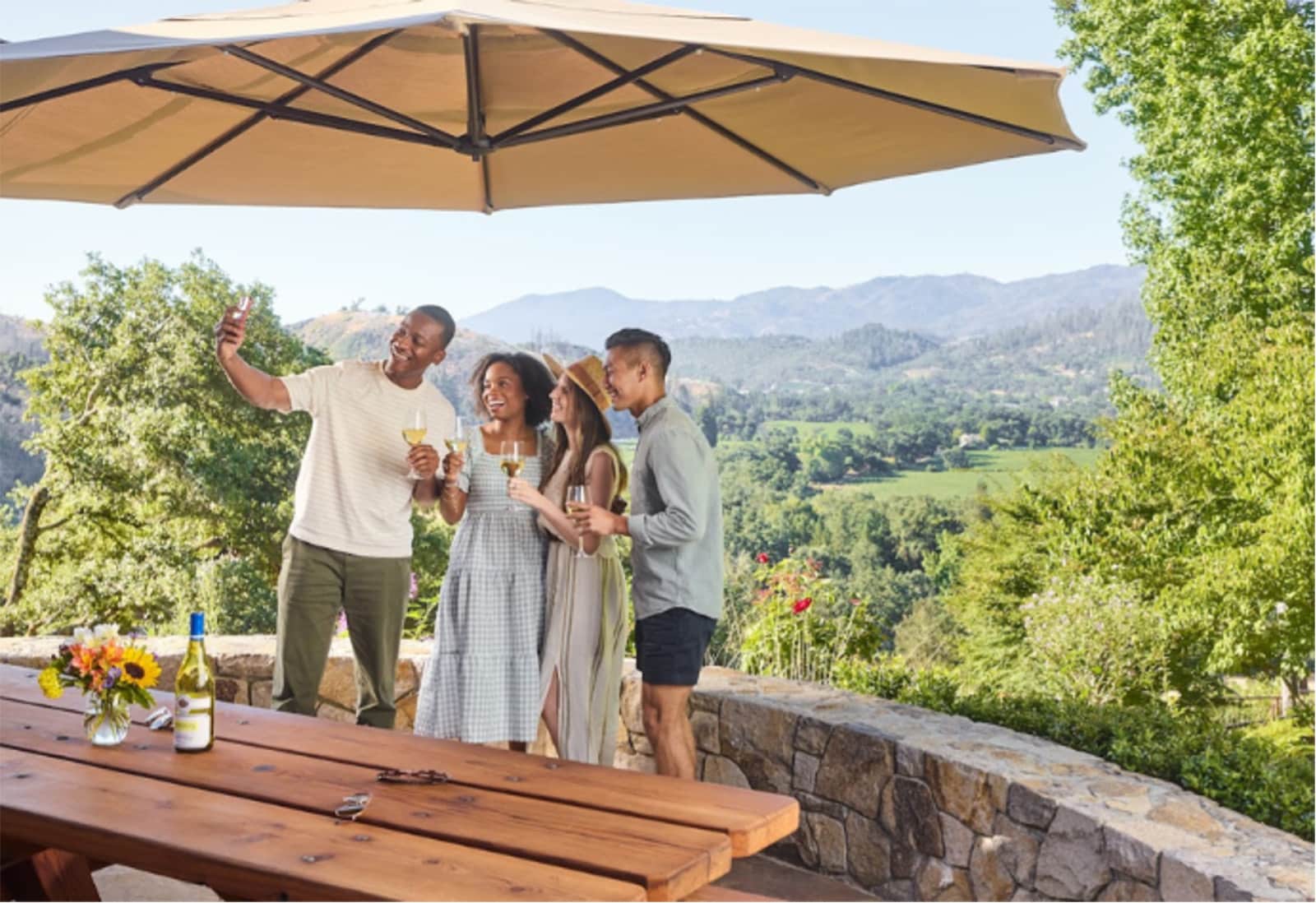Friends taking selfie at outdoor vineyard gathering.