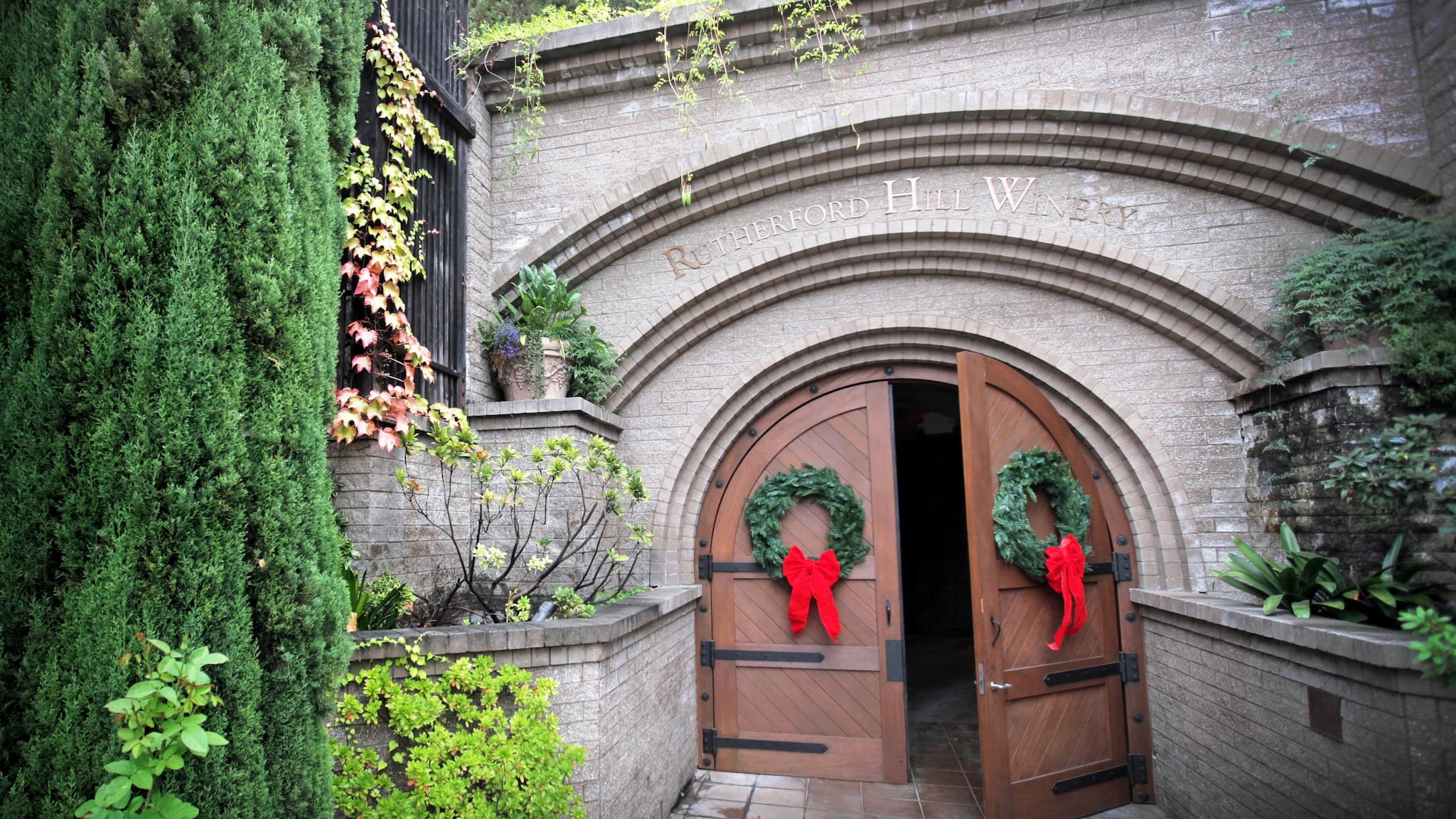 Winery entrance with festive wreaths and greenery.