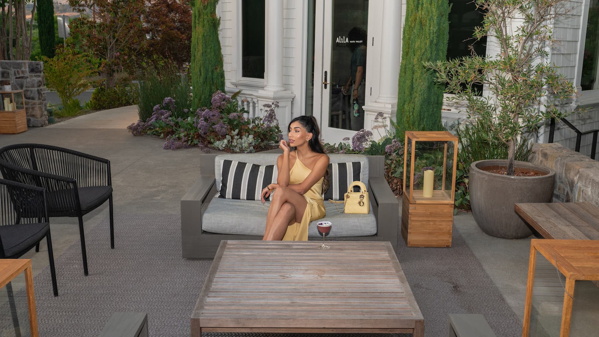 Woman sitting outside on a patio sofa.