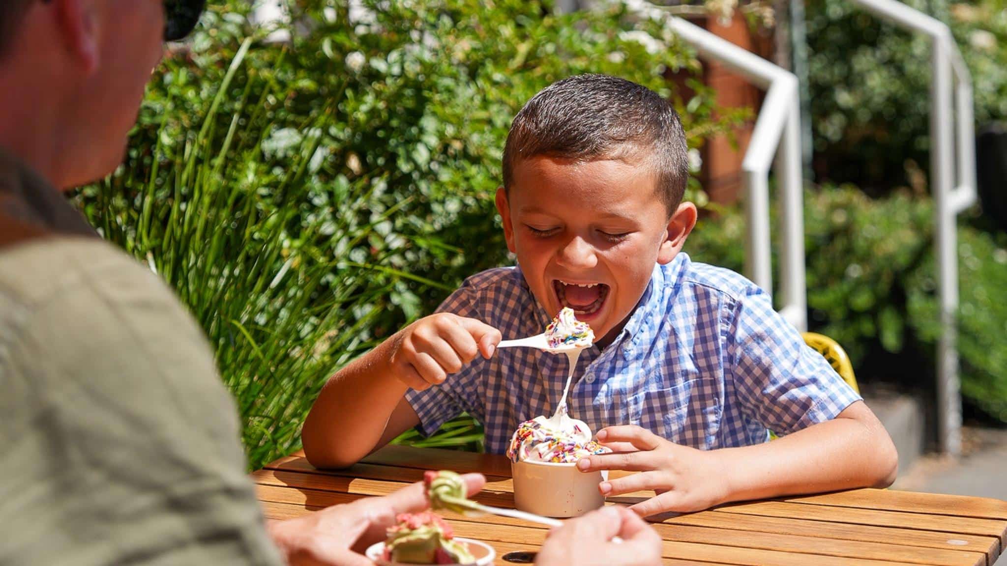 Boy eating ice cream with sprinkles outdoors