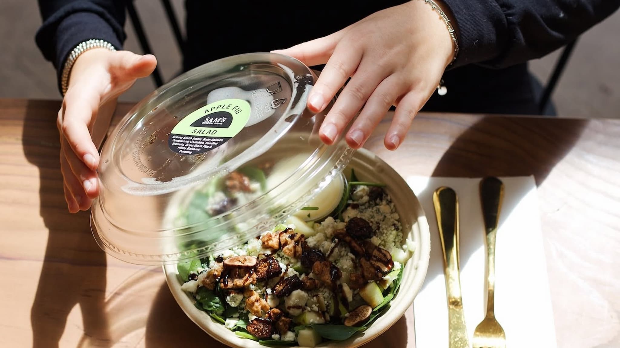 Hands opening apple fig salad bowl