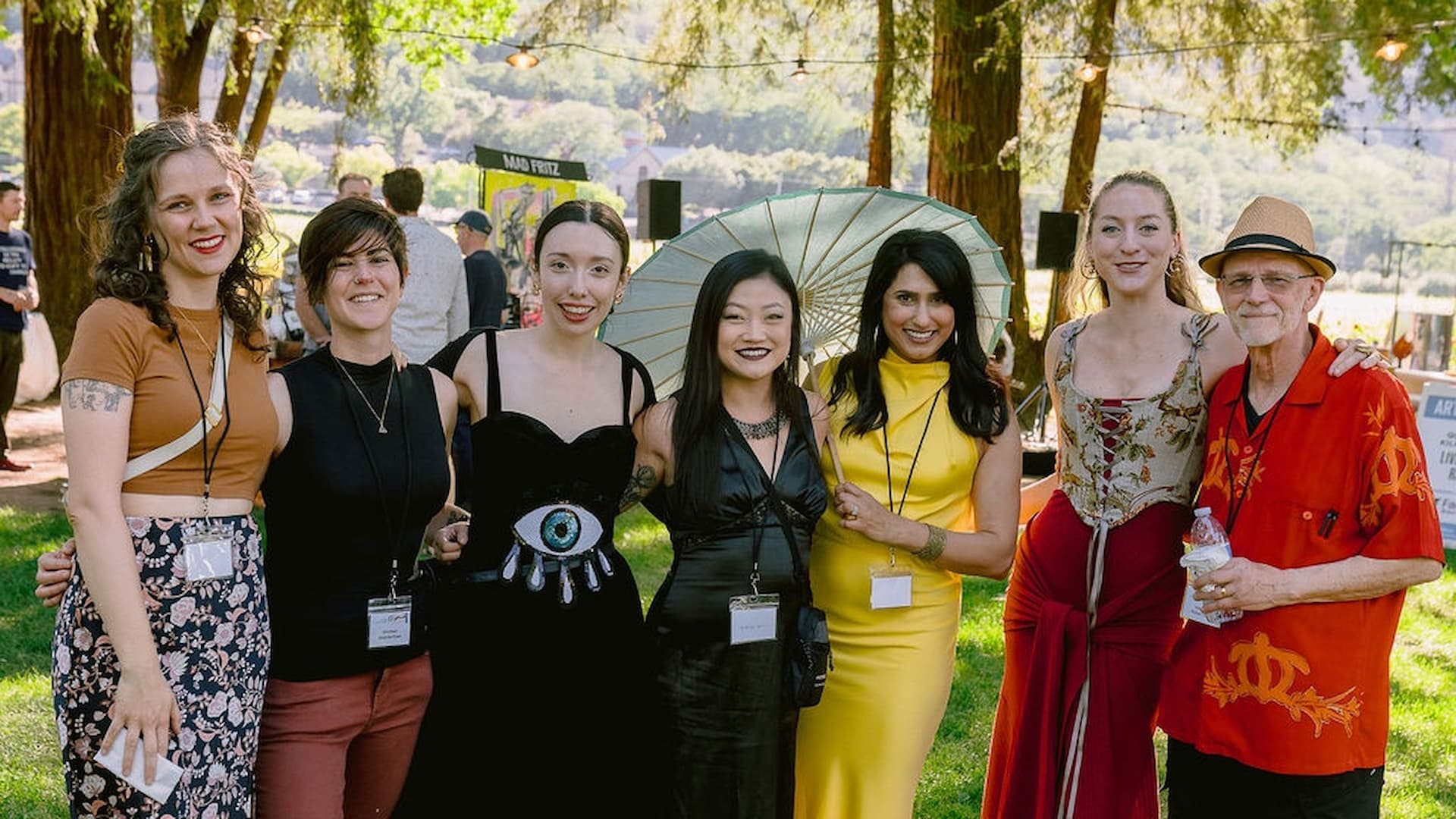 Group of people smiling outdoors at event.