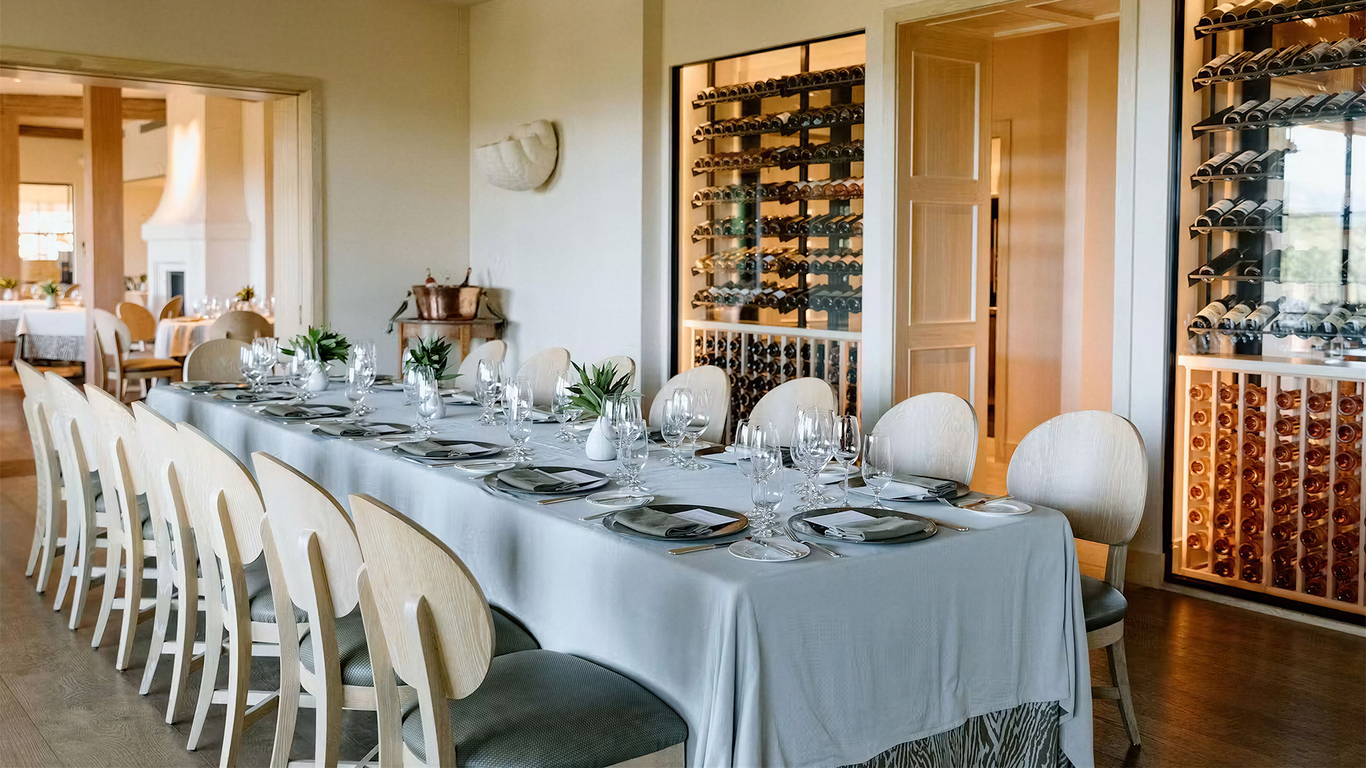 Elegant dining table beside glass wine cellar
