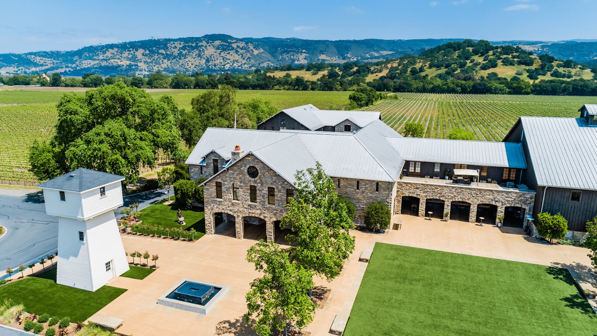 Scenic vineyard estate with hills and blue sky.