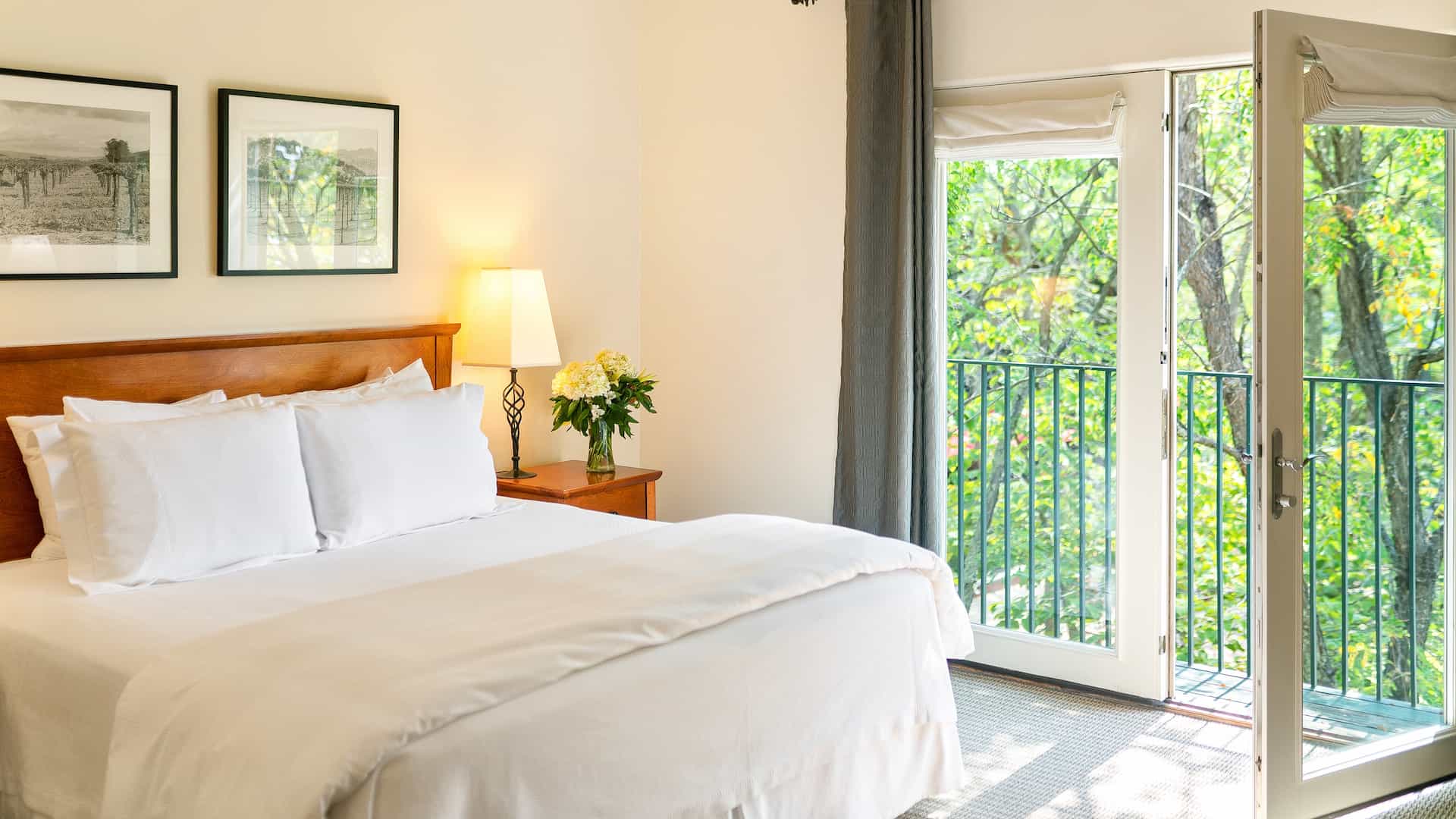 Bright bedroom with balcony and greenery view.
