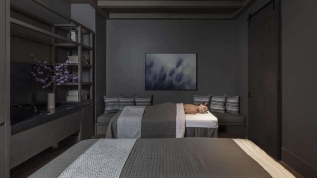 Relaxing modern spa room with massage tables.