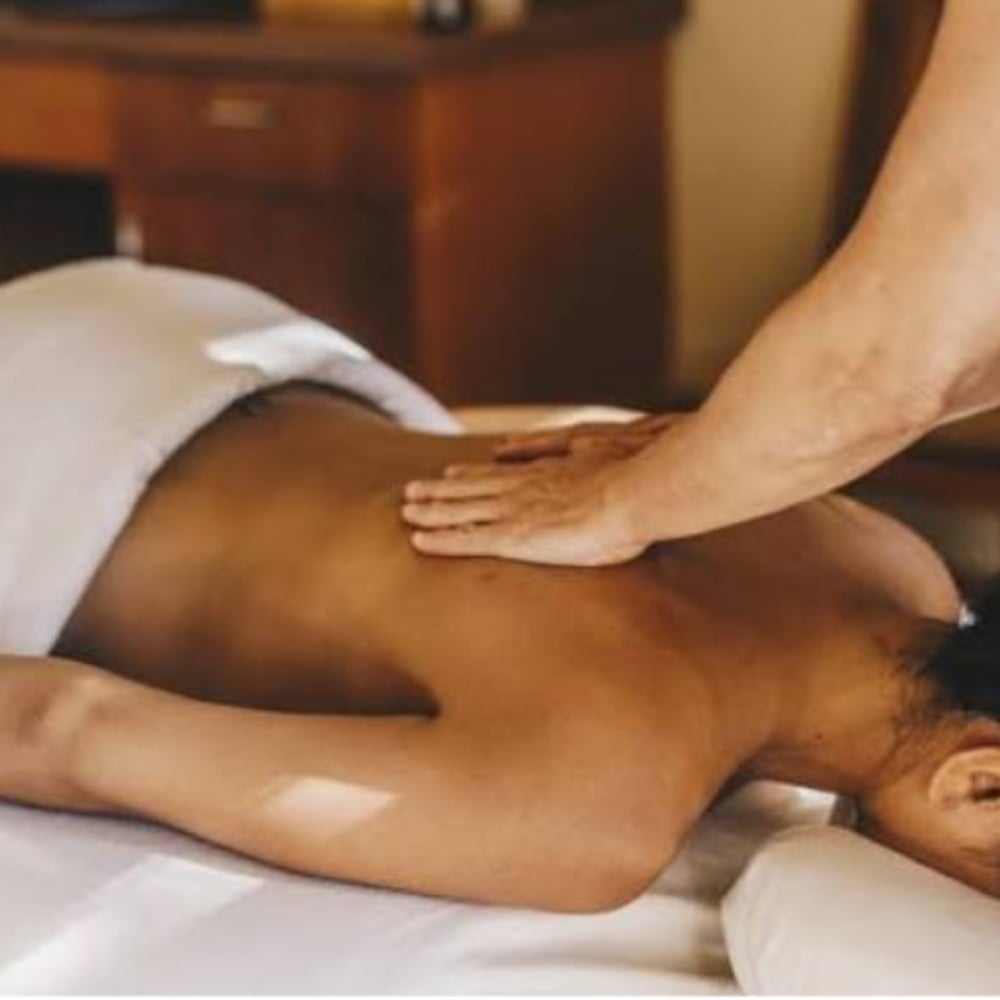Person receiving back massage at spa