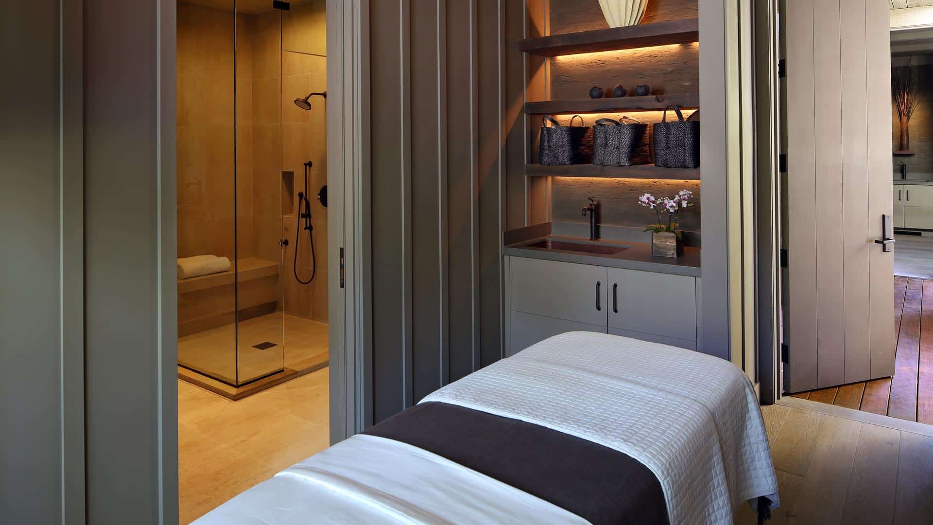 Luxury spa room with shower and massage table.