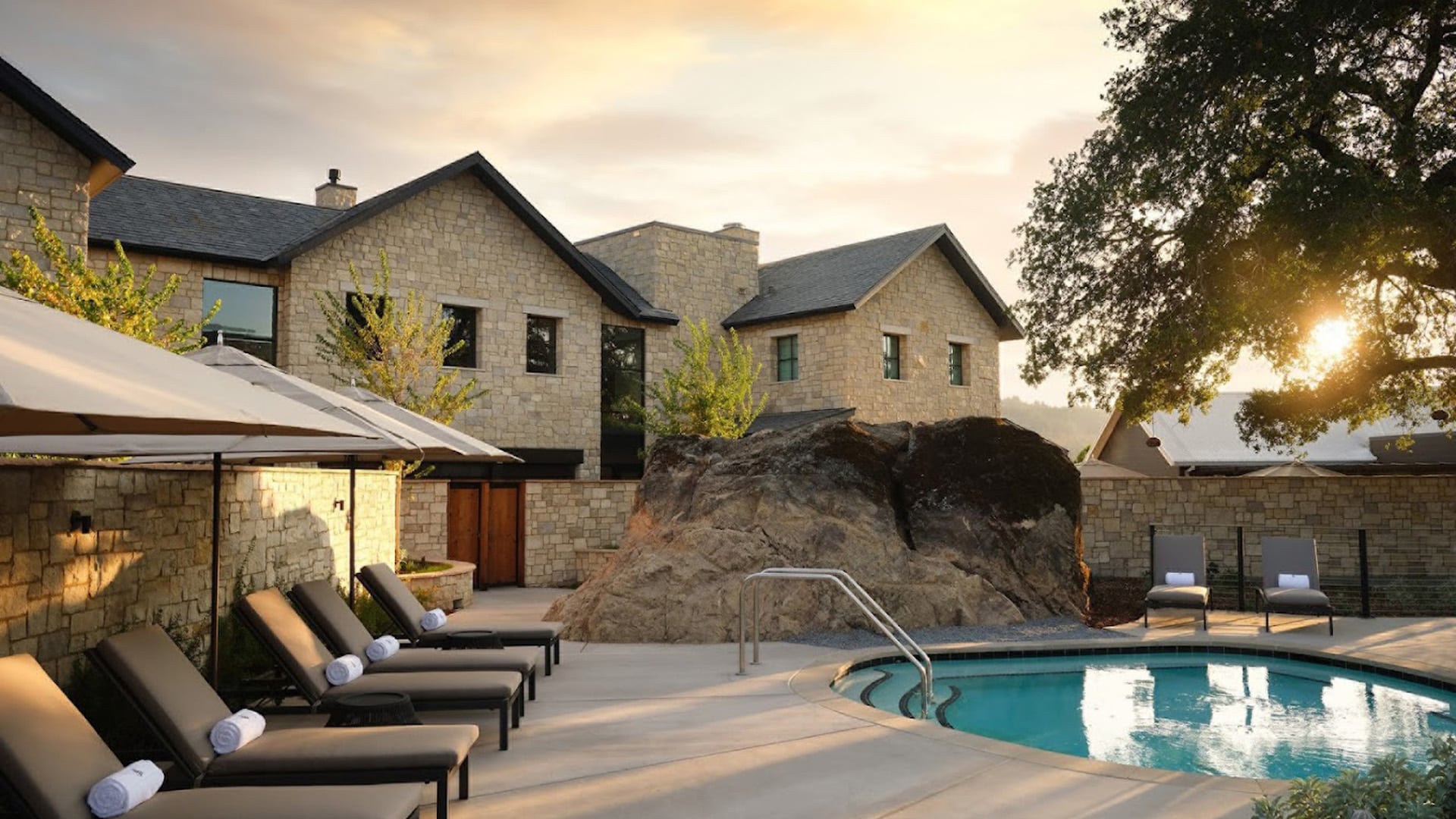 Luxurious stone villa with serene pool and loungers.