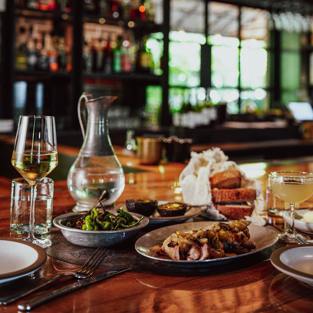 Restaurant table with wine, bread, and plated dishes