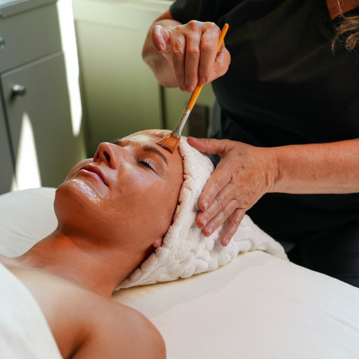 Woman receiving facial mask at spa