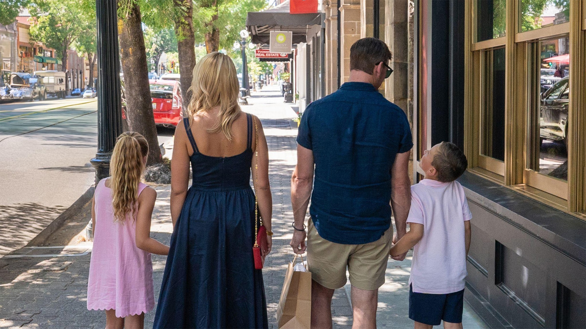 Family walking on a tree-lined street