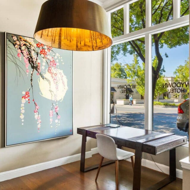 Modern office desk with art and large window view