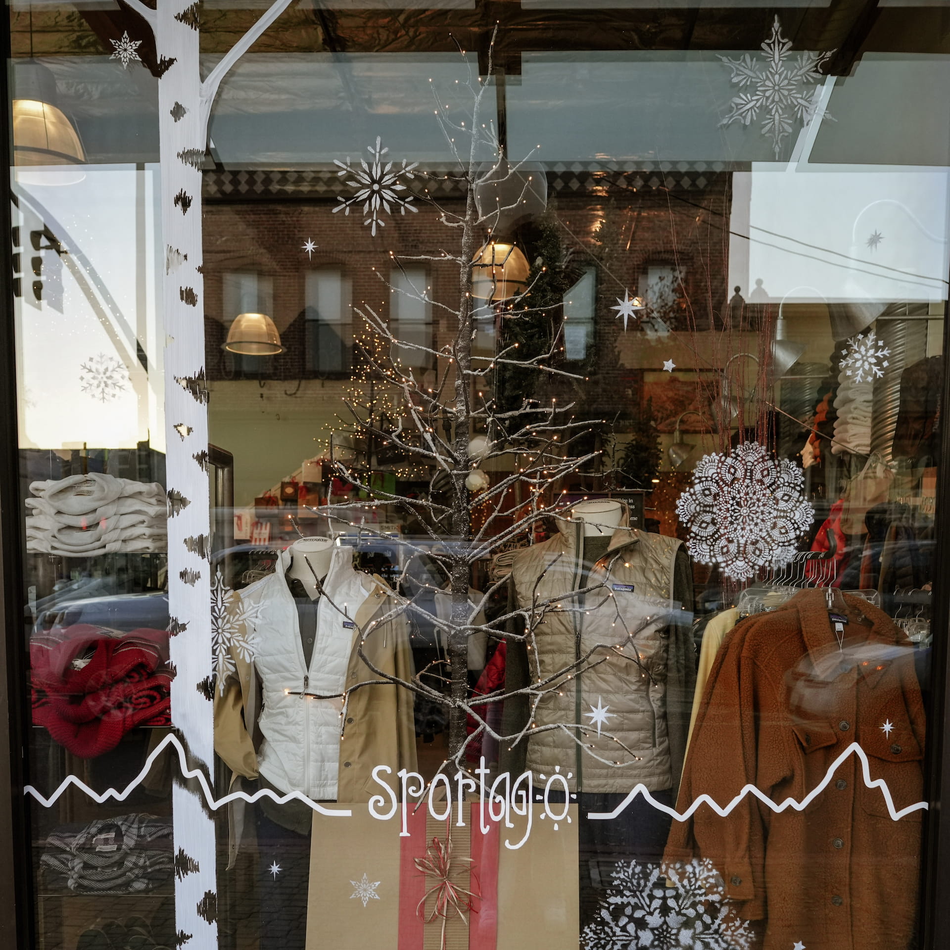 Winter clothing display with snowflake decorations.
