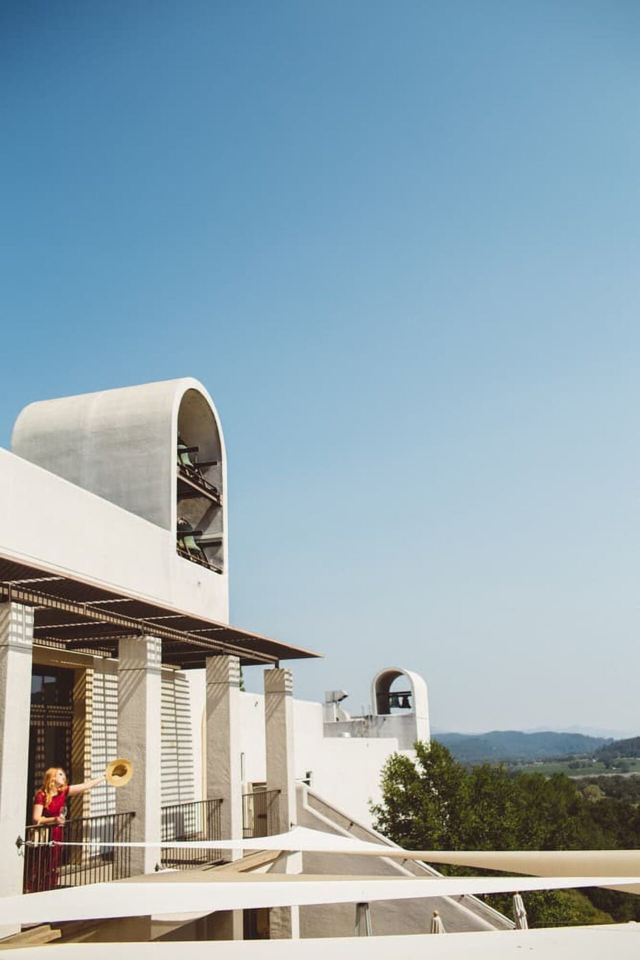 Architectural building with bells and person on balcony