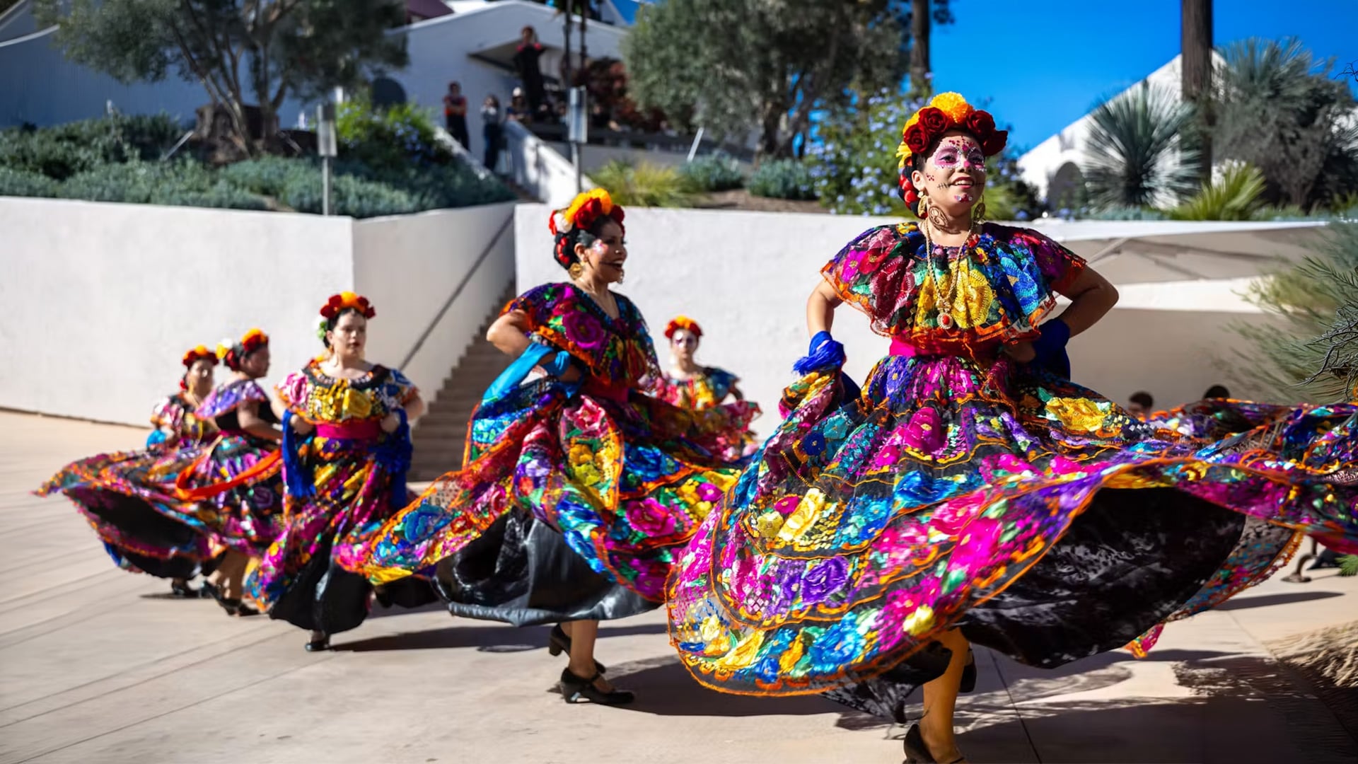 Folklórico dancers twirl colorful skirts in daylight