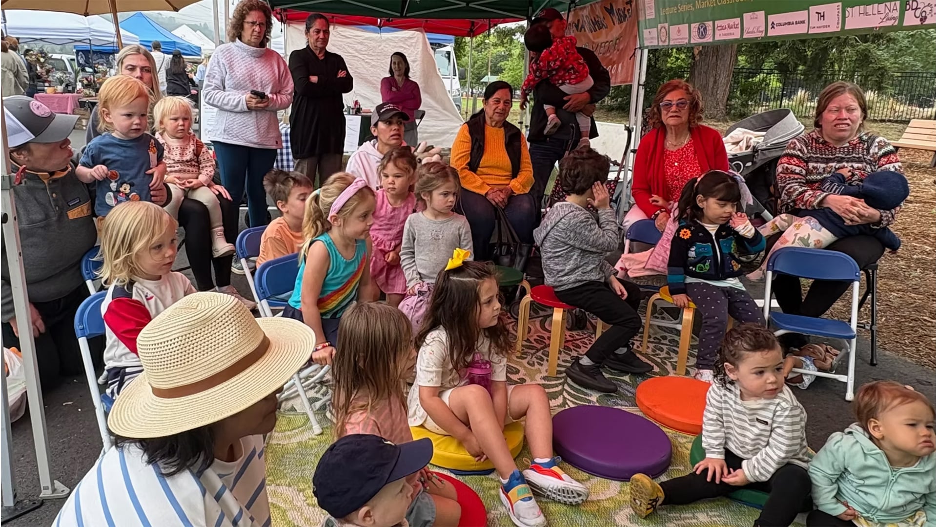 Children gathered under tent at outdoor market