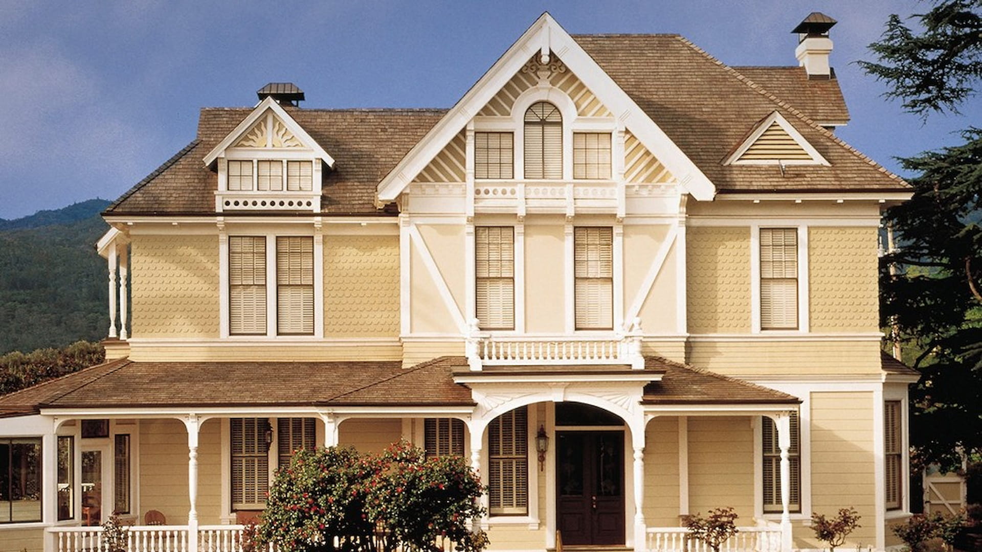 Victorian-style yellow house with rooftop details
