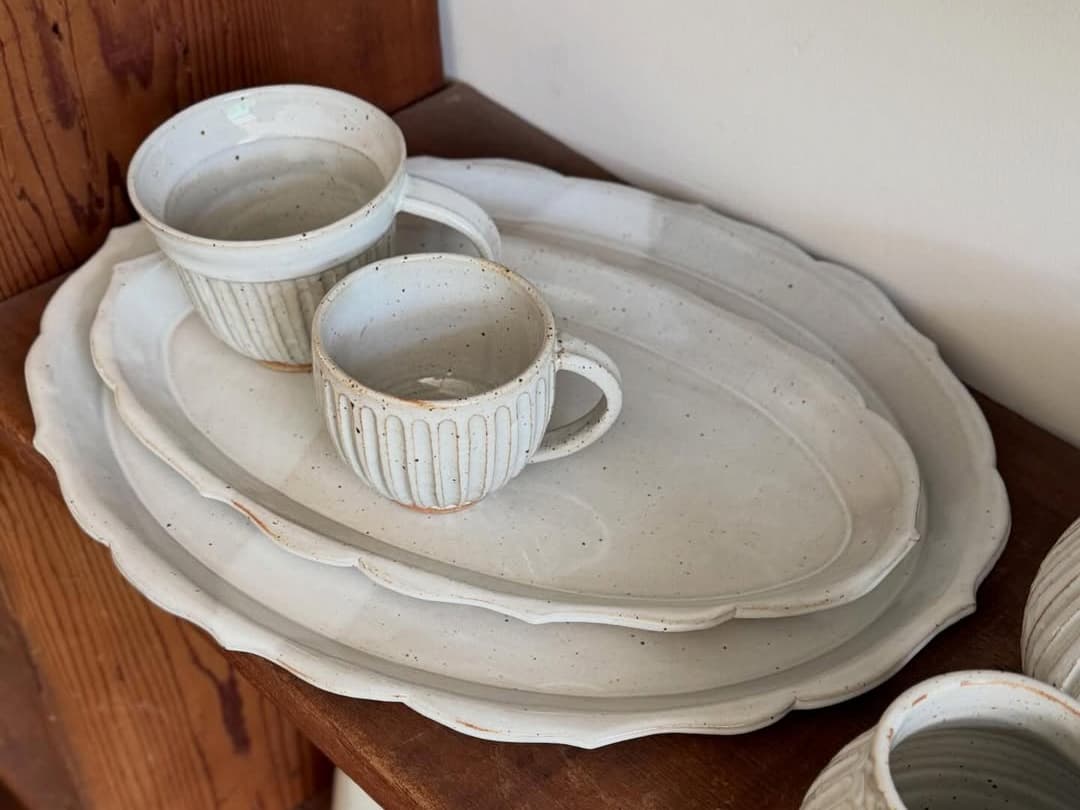White ceramic plates and cups on wooden shelf
