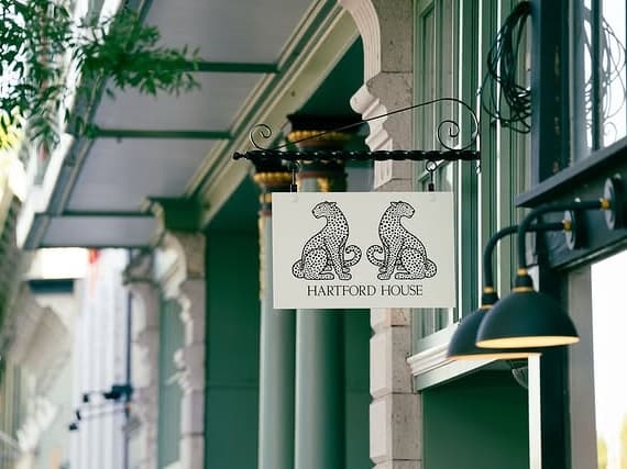Hartford House hanging sign on green facade