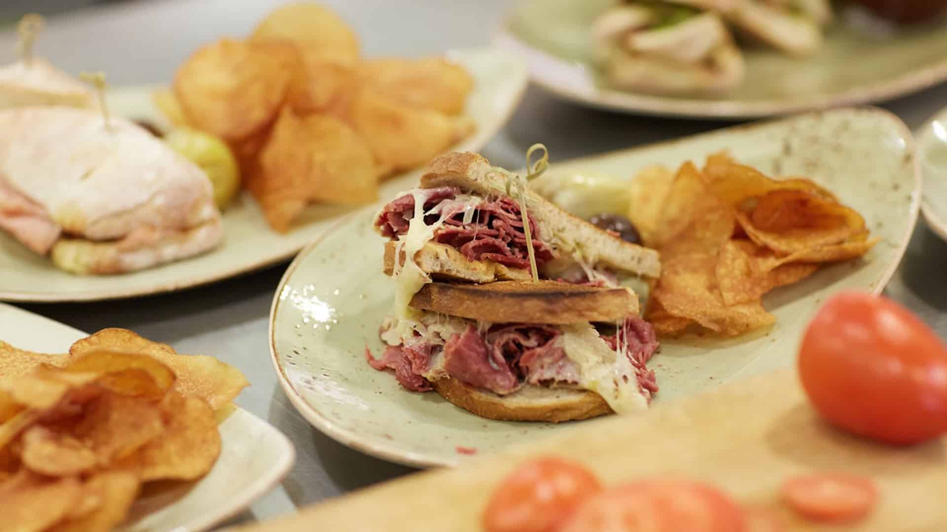 Reuben sandwich with chips and tomatoes