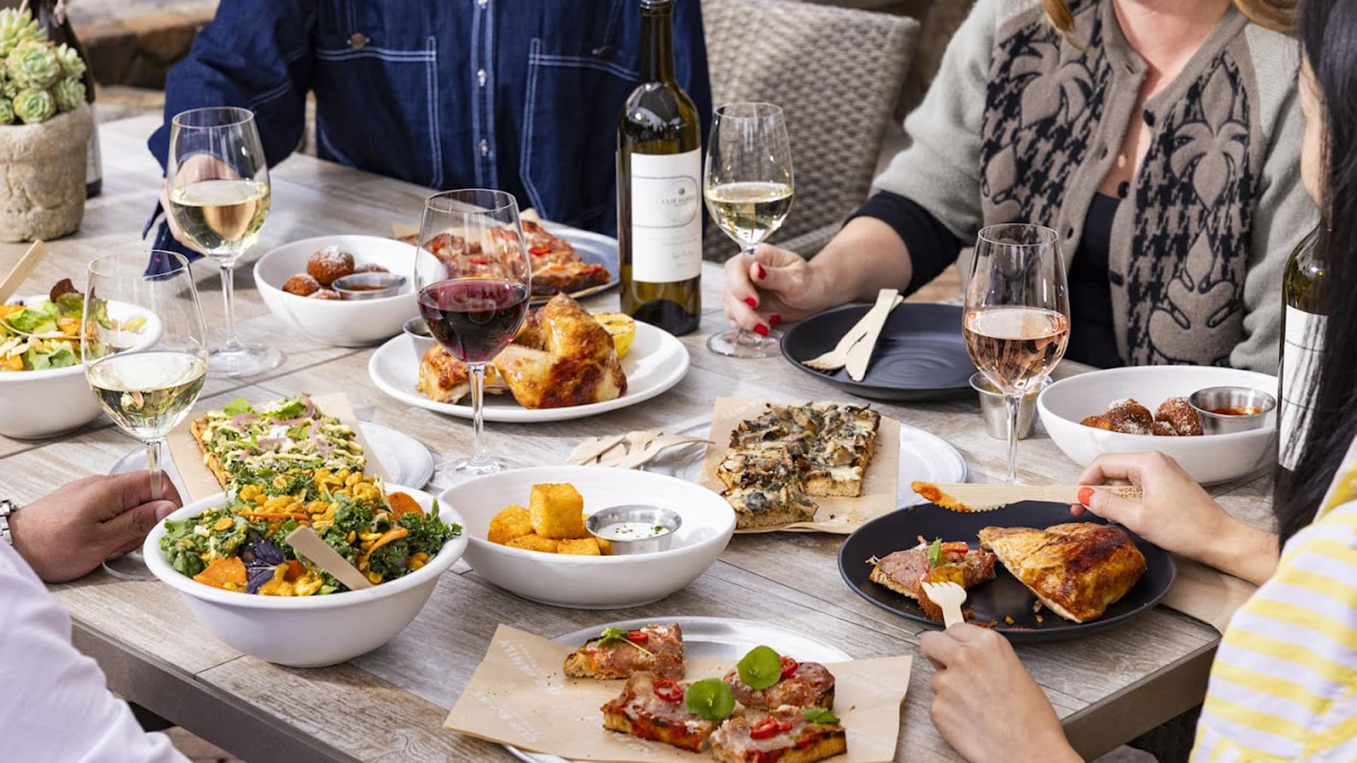 Dining table with assorted food and wine.