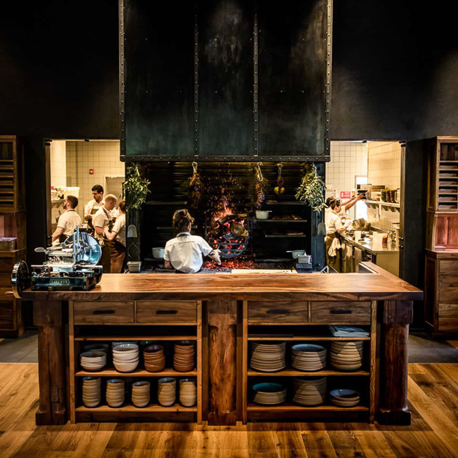 Chefs working in a rustic restaurant kitchen.