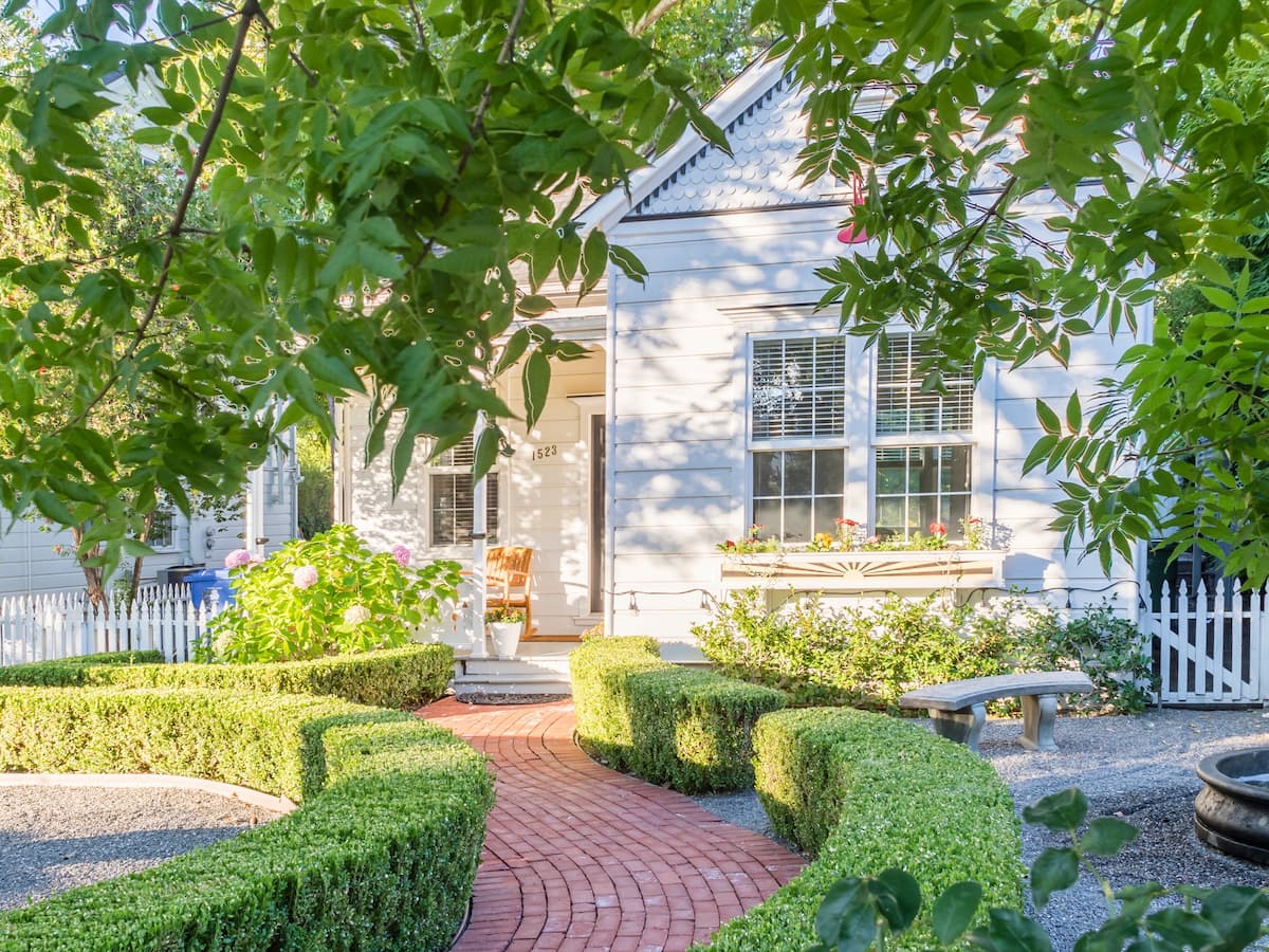Charming white cottage with brick garden pathway