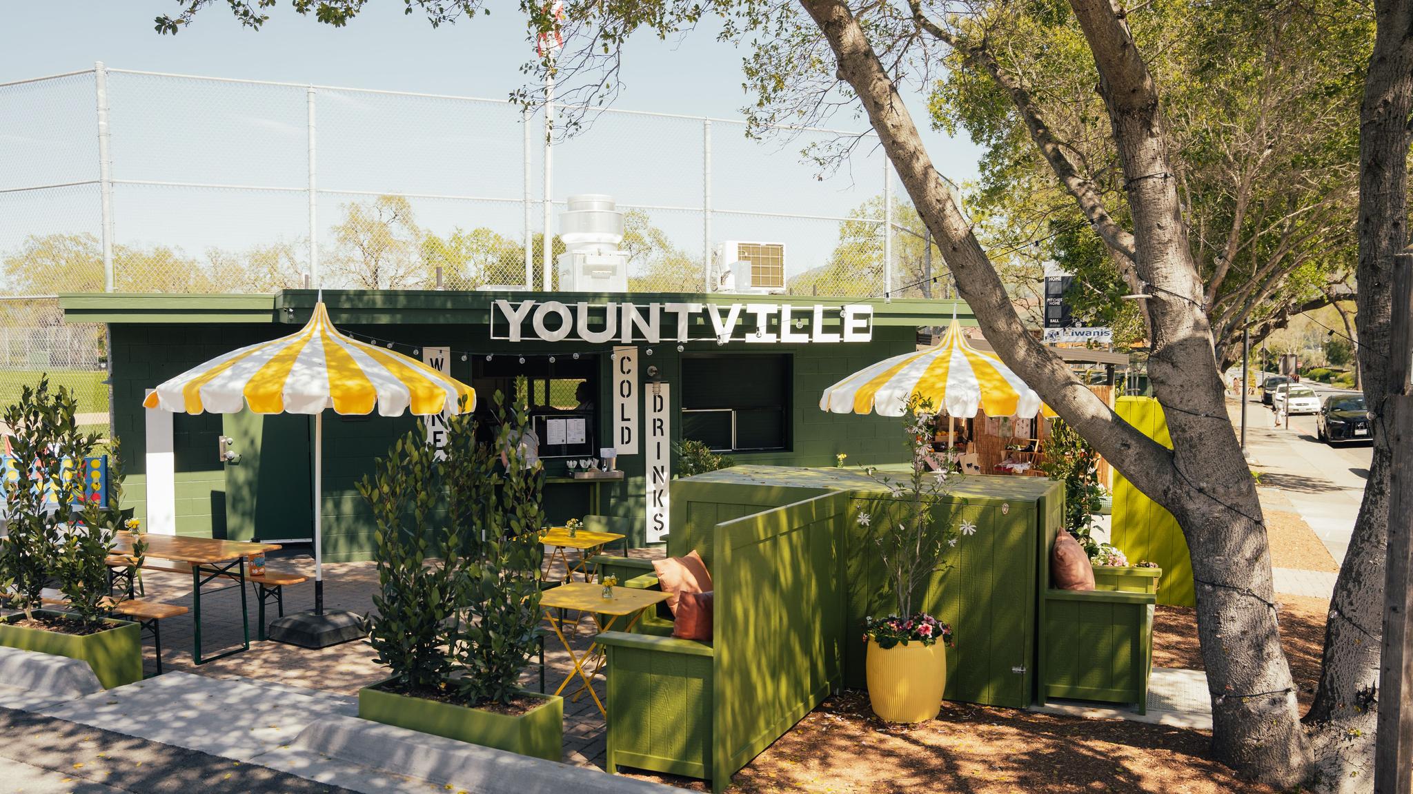 Outdoor cafe with yellow umbrellas and seating area.