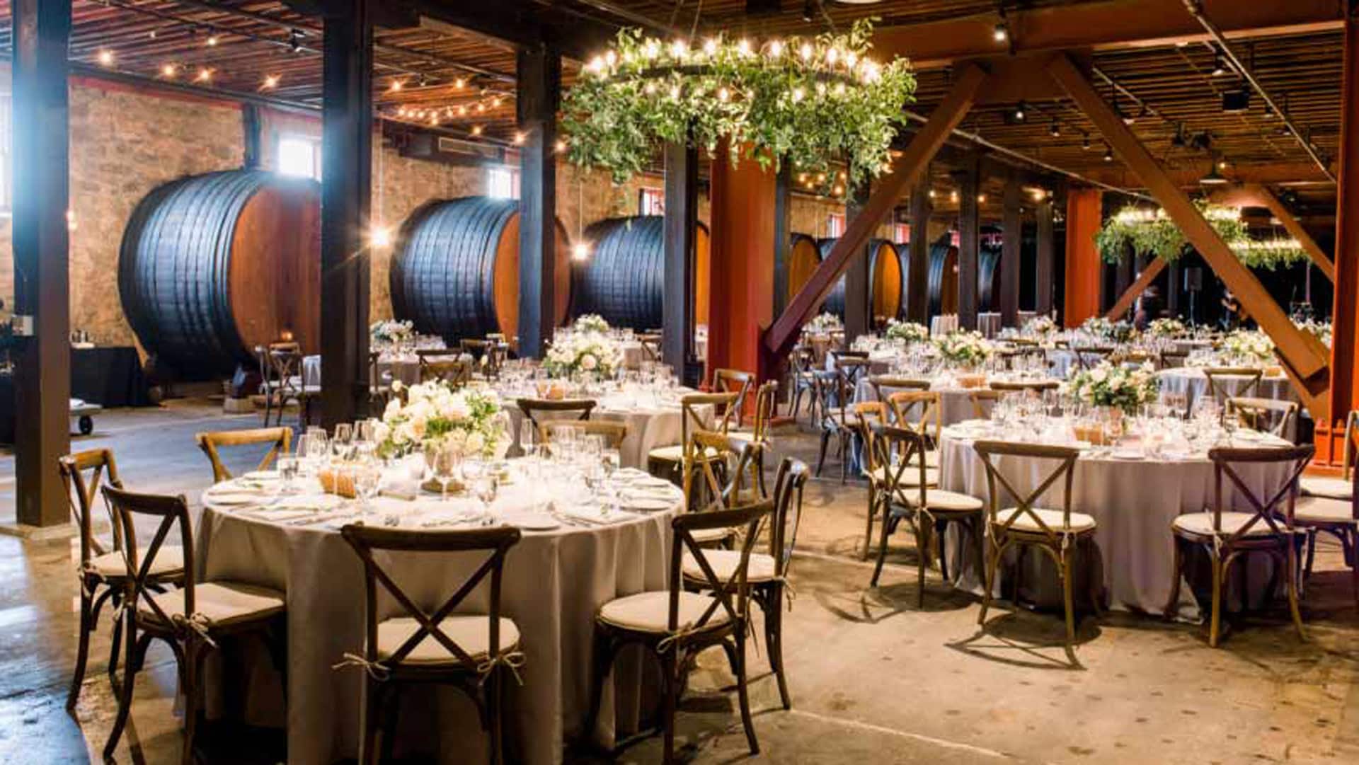 Elegant wine cellar event setup with round tables.