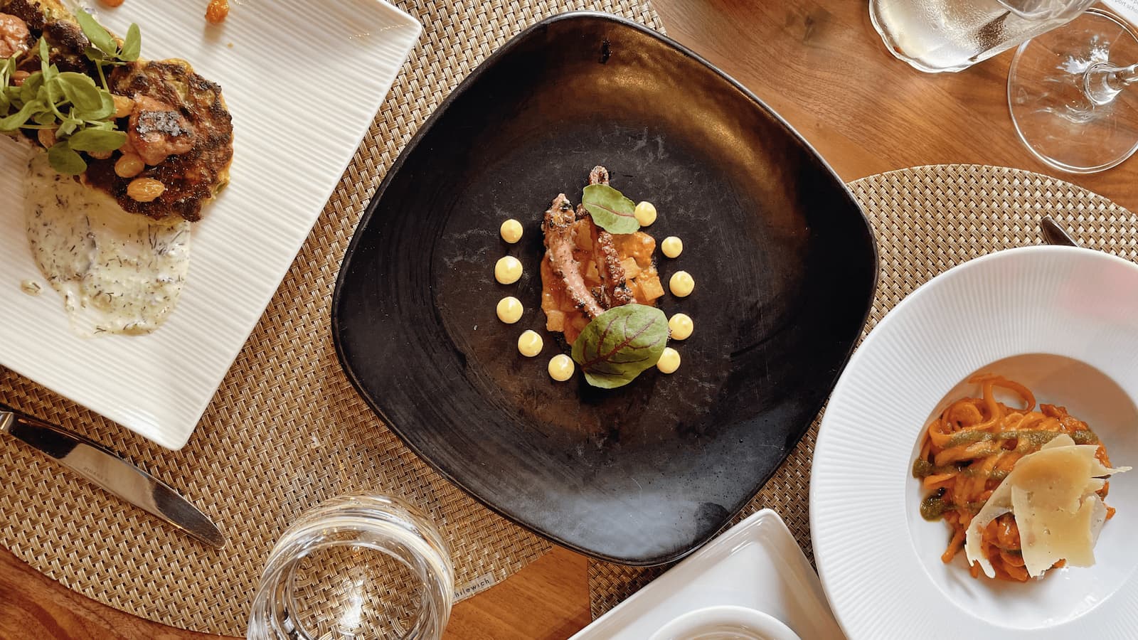 Fine dining dishes on a wooden table.