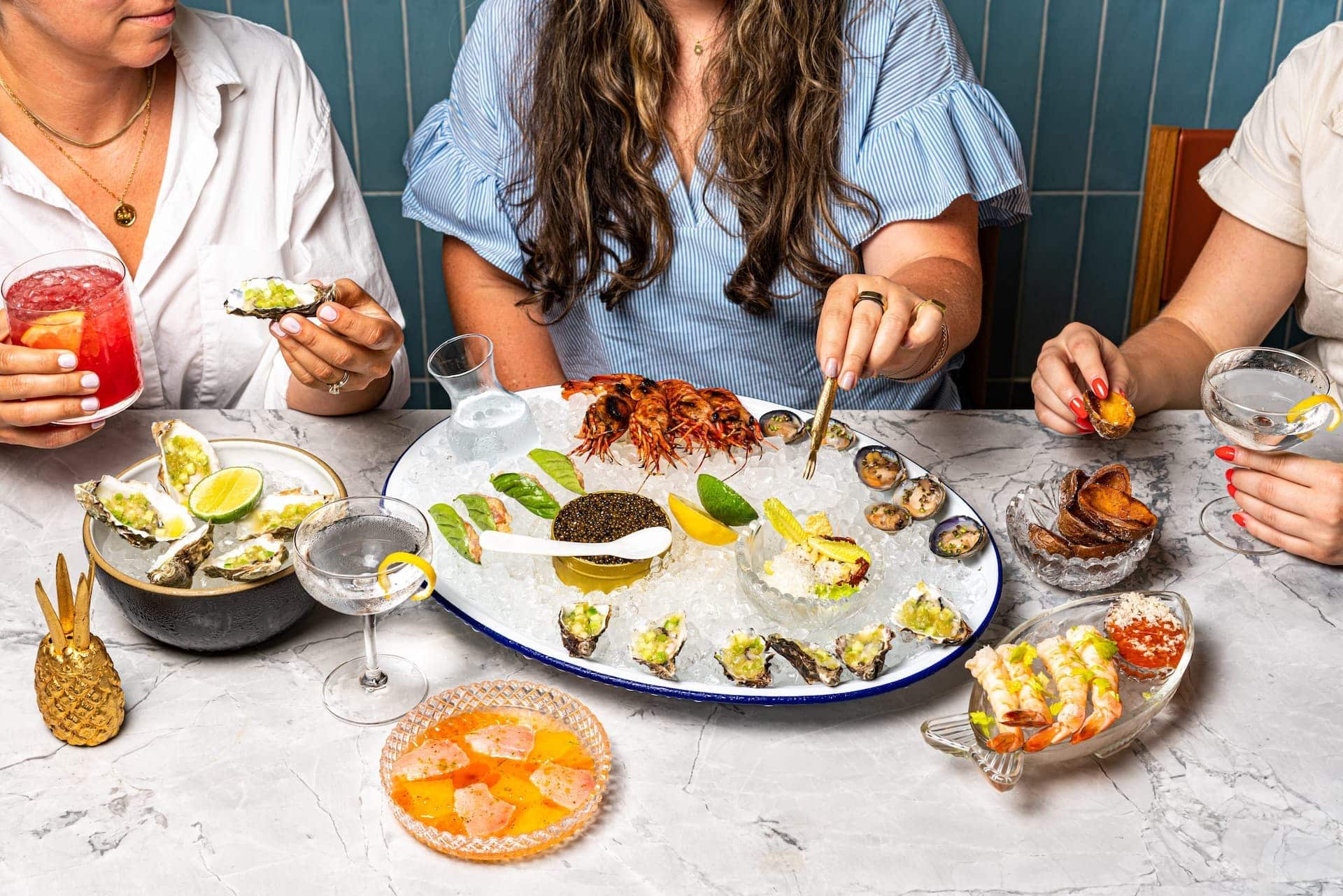 People enjoying seafood and drinks at a table