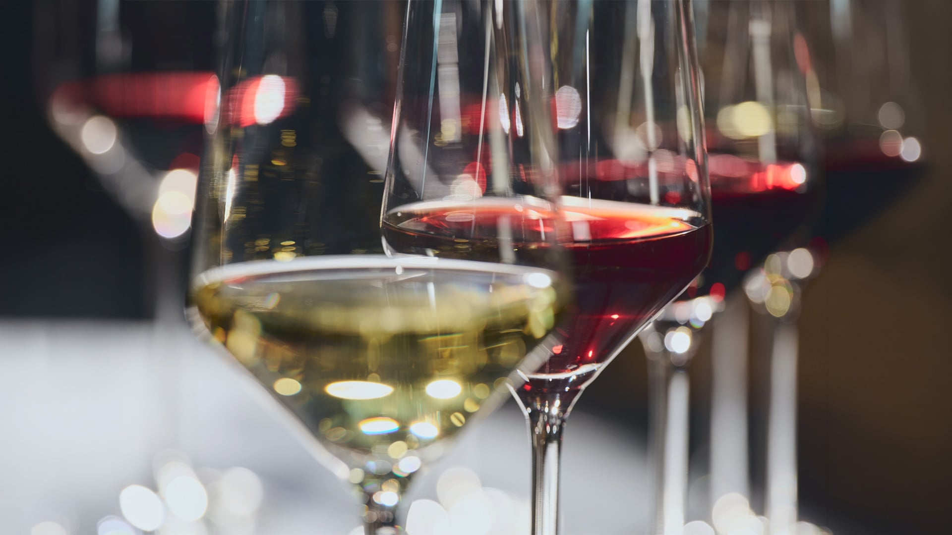 Red and white wine glasses with blurred lights