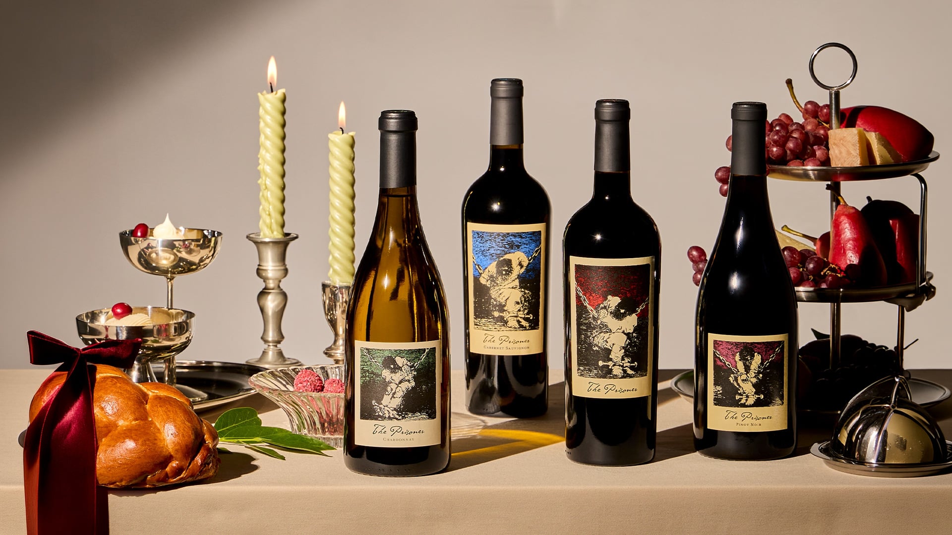 Wine bottles, candles, roast chicken, and fruit display